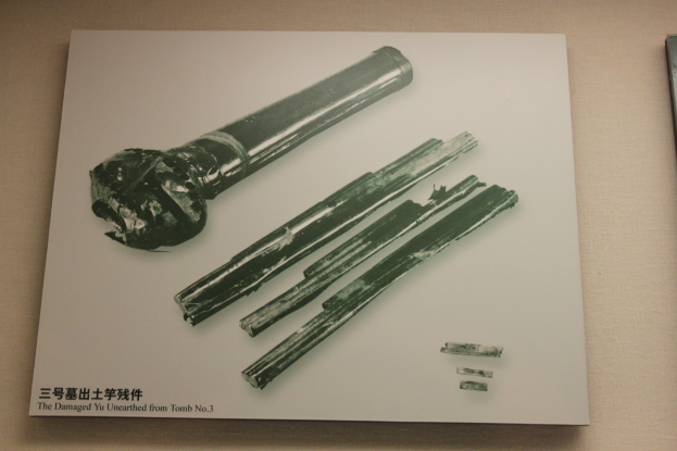 Ein Tisch mit einem Buch, das ein Bild einer Feuerwaffe mit langem Lauf und einem Griff zeigt, begleitet von Text.