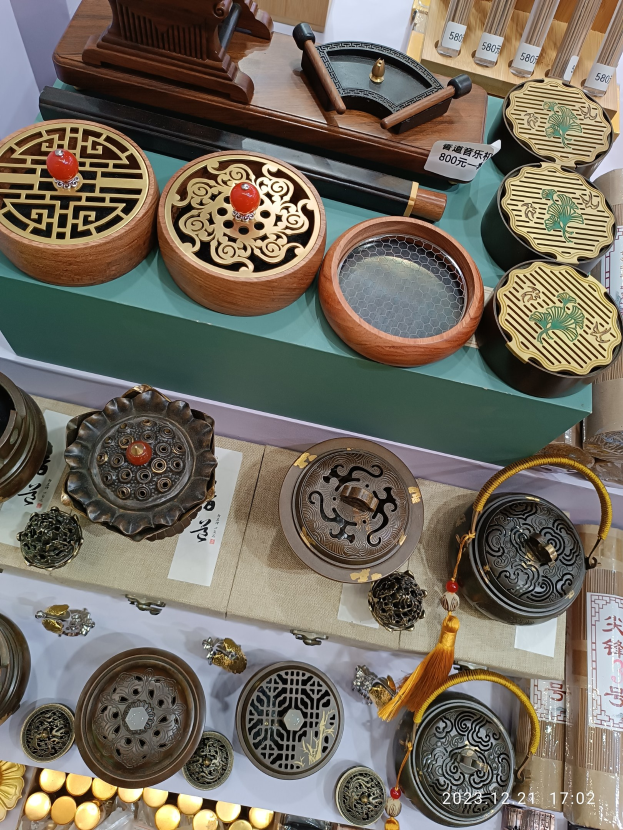 Ein Tisch mit verschiedenen chinesischen Räucherstäbchen, Schachteln, Papieren mit Text und anderen Gegenständen, die likely für ein chinesisches Neujahrsfest arrangiert sind.