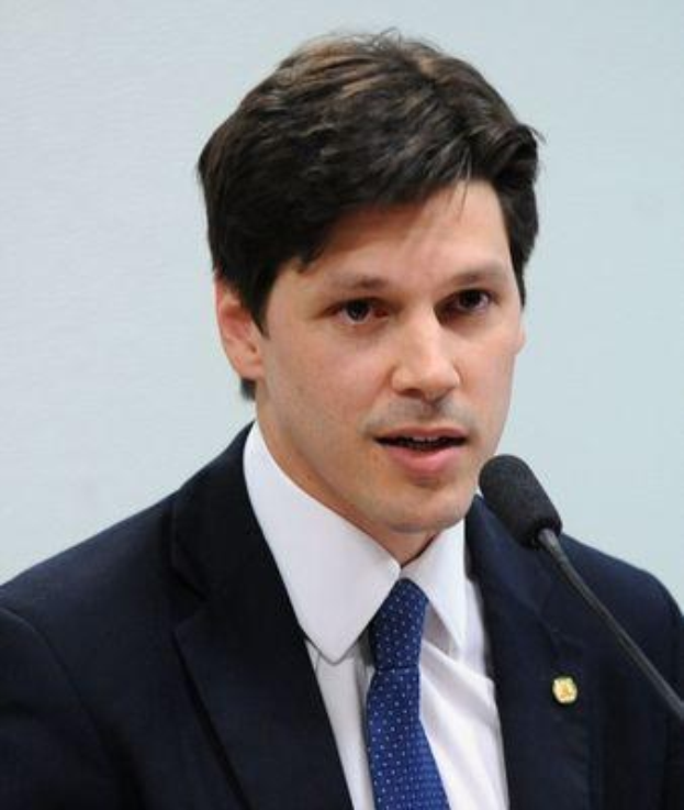 Ein Mann im Anzug und Krawatte spricht vor einer Wand in ein Mikrofon und scheint eine Regierung genehmigte Gesetzesvorlage zur Internet-Sperre anzusprechen.