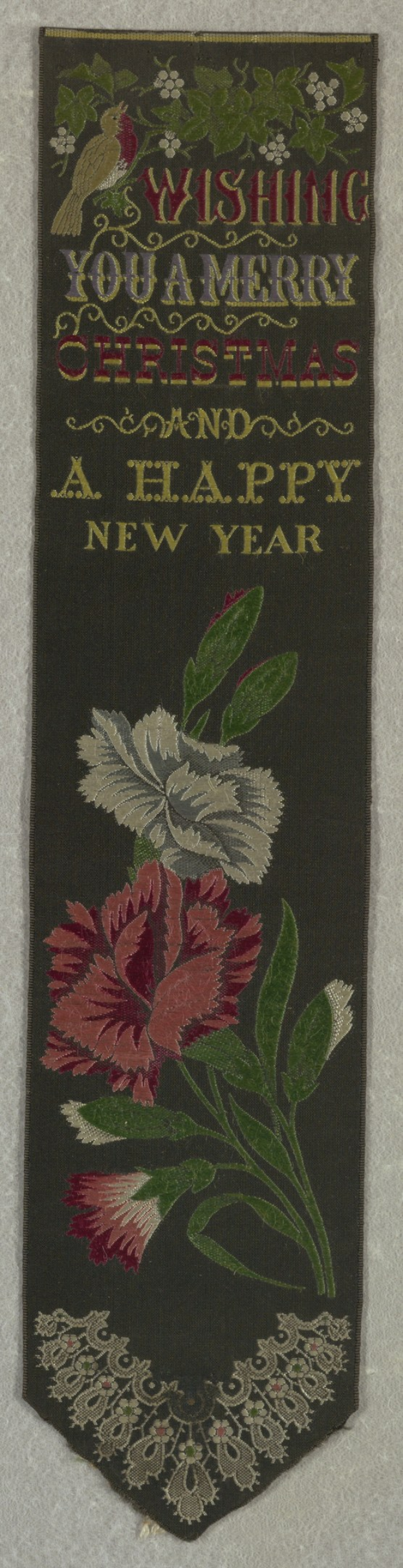 Ein schwarzes Banner mit roter und weißer Blumenstickerei, das den Text 'Frohe Weihnachten und ein glückliches neues Jahr' trägt, umgeben von bunten Blumen und Blättern.
