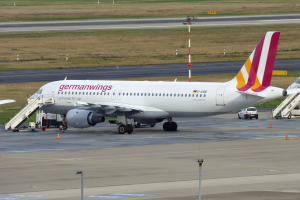 Germanwings Airbus A320-200 am Frankfurt Airport mit Fahrzeugen, Verkehrskegeln, Pfosten und Gras im Hintergrund geparkt.