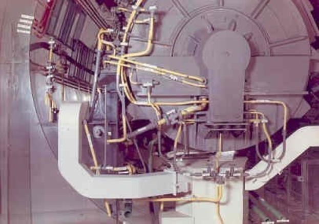 Großes industrielles Beschleunigergerät mit mehreren angeschlossenen Komponenten und Verdrahtung innerhalb eines Gebäudes.