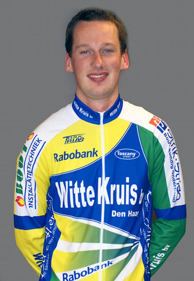 Ein männlicher Sportler posiert für ein Foto mit sichtbaren Sponsorenlogos auf seinem Hemd.