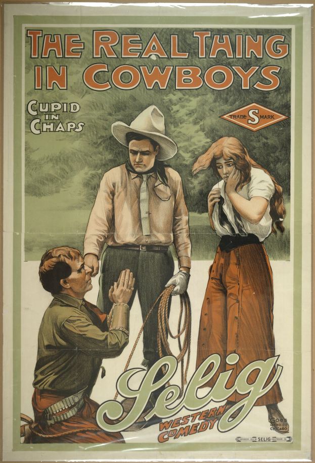 Plakat an einer Wand mit drei Personen – zwei Männer mit Cowboyhüten und eine Frau in einem langen Kleid – mit der Aufschrift "Das echte Ding bei Cowboys" in fetter schwarzer Schrift auf einem hellgelben Hintergrund.