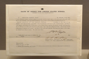 Ein Blatt Papier mit der Aufschrift "Eid für Bundesrichter" darauf, das auf einem Tisch vor einer Wand liegt.